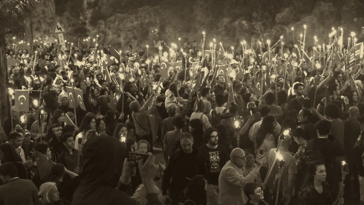 Torches burning on castle walls at night.